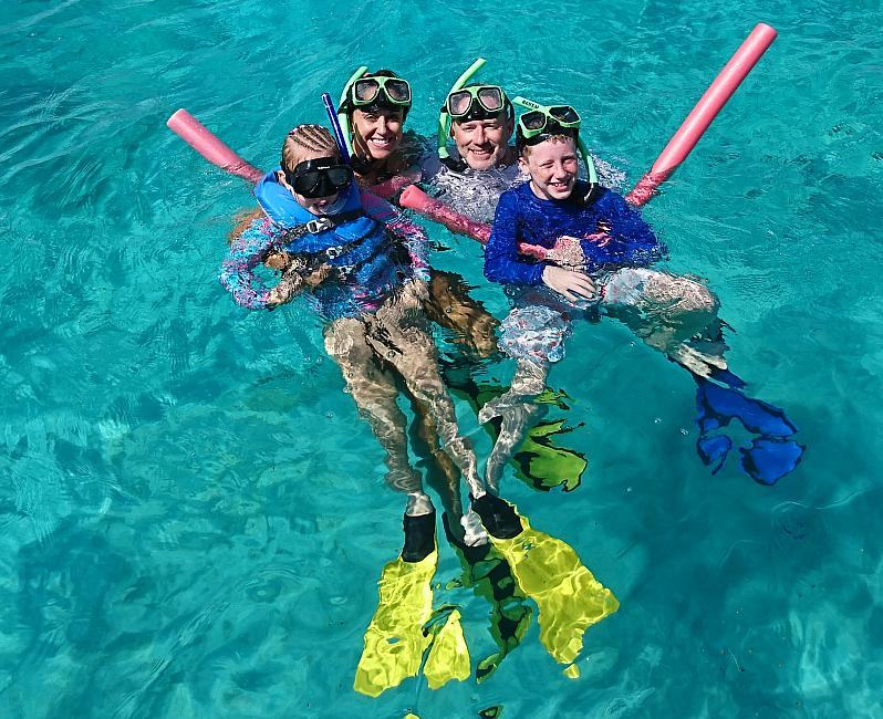 Family snorkeling in clear turquoise water